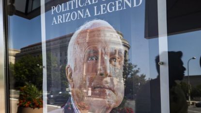 Пешеходци се отразяват в първата страница на „Аризона репюбликс“, посветена на починалия на 25 август сенатор Джон Маккейн“, пред Музея на новините във Вашингтон.