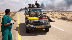 На няколко километра от Сирт войници на ПНС превозват ранен войник, за да получи медицинска помощ