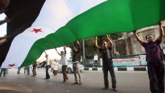 Сирийци протестират пред седалището на Арабската лига в Кайро, като развяват своя национален флаг.